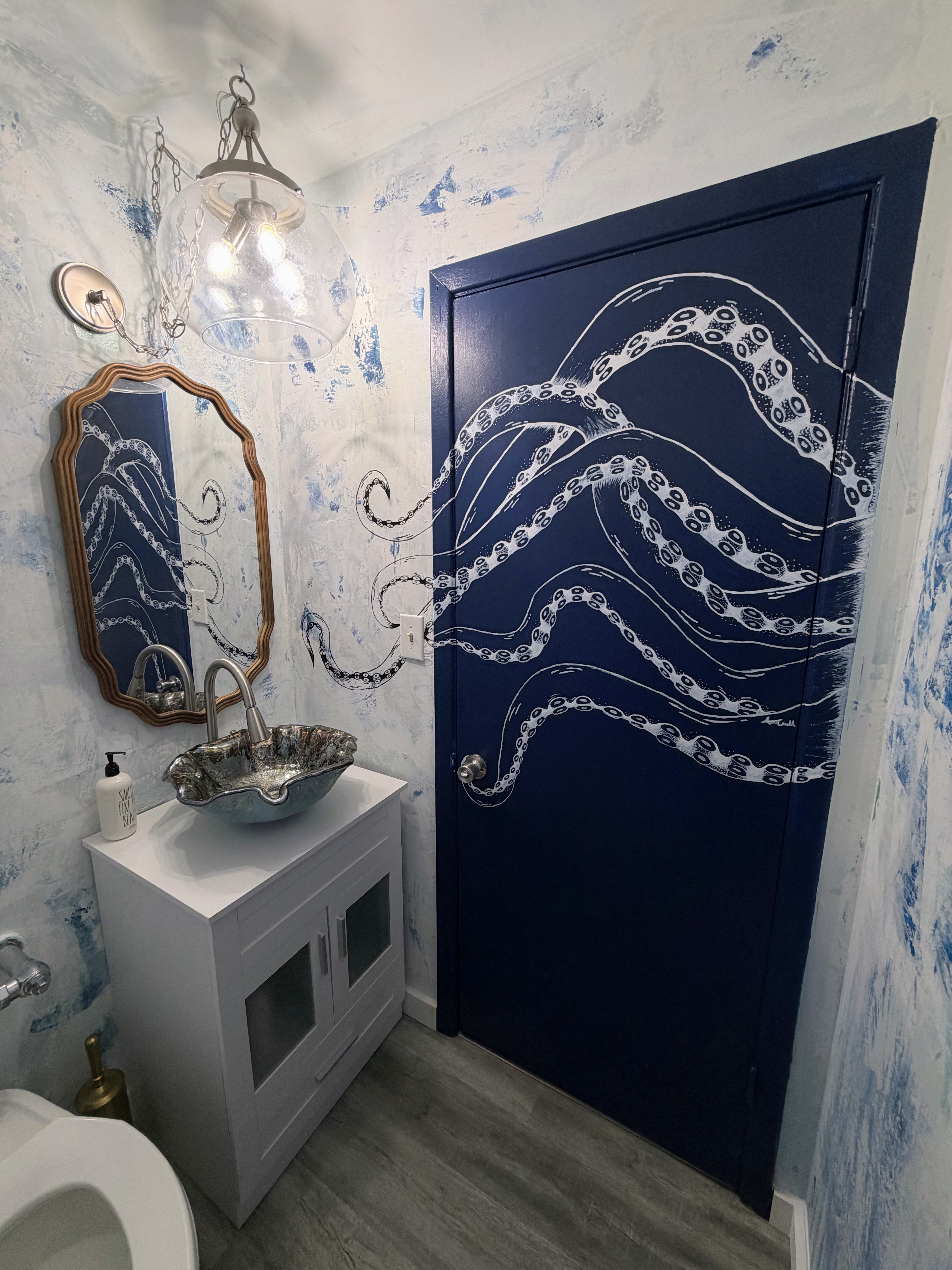 Finished bathroom — Alayna’s octopus tentacles spilling across the navy door.