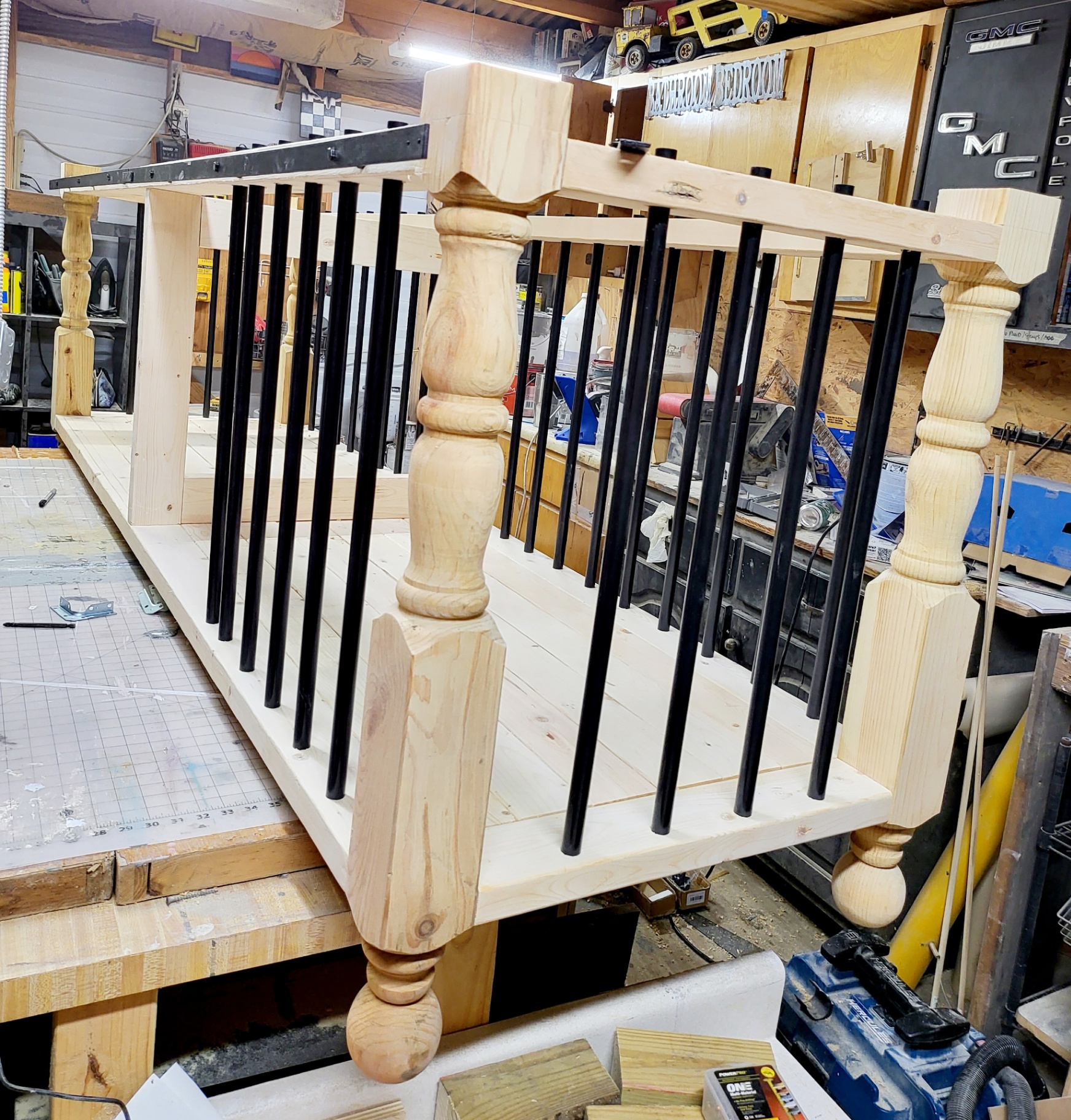 Raw frame in the workshop — turned legs and iron spindles.