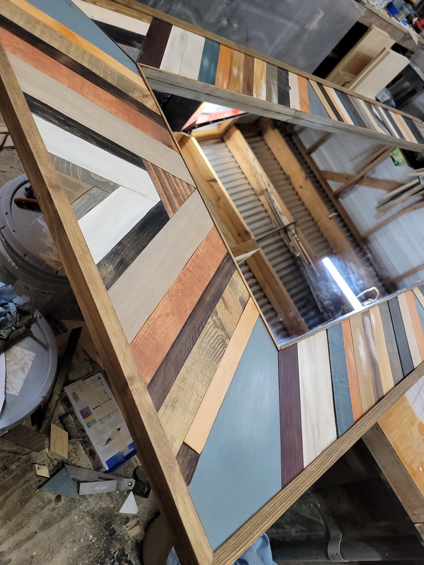 Angled workshop view of the custom mirror before installation.