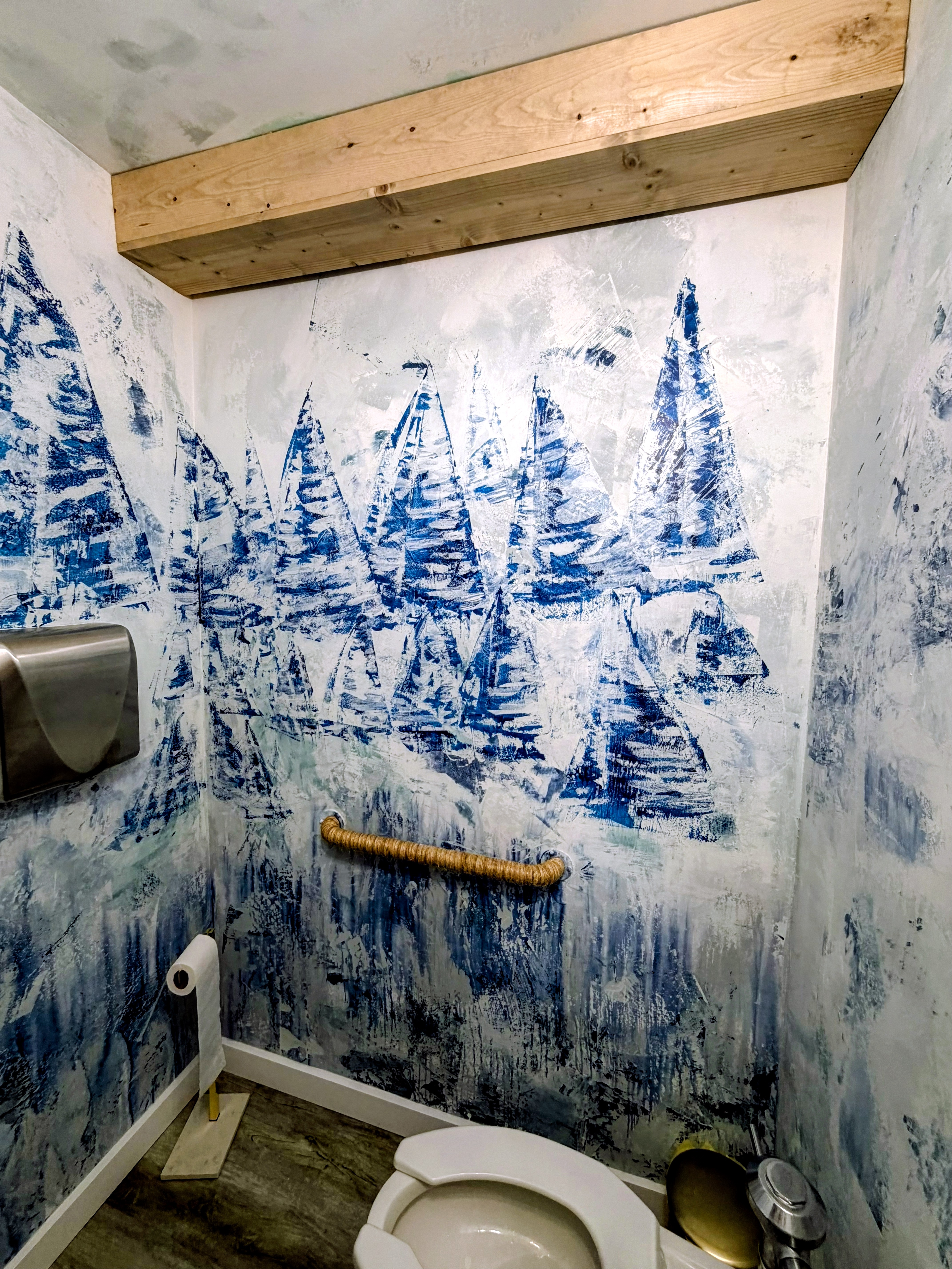 Abstract sailboats drifting across the distressed blue-and-white walls.