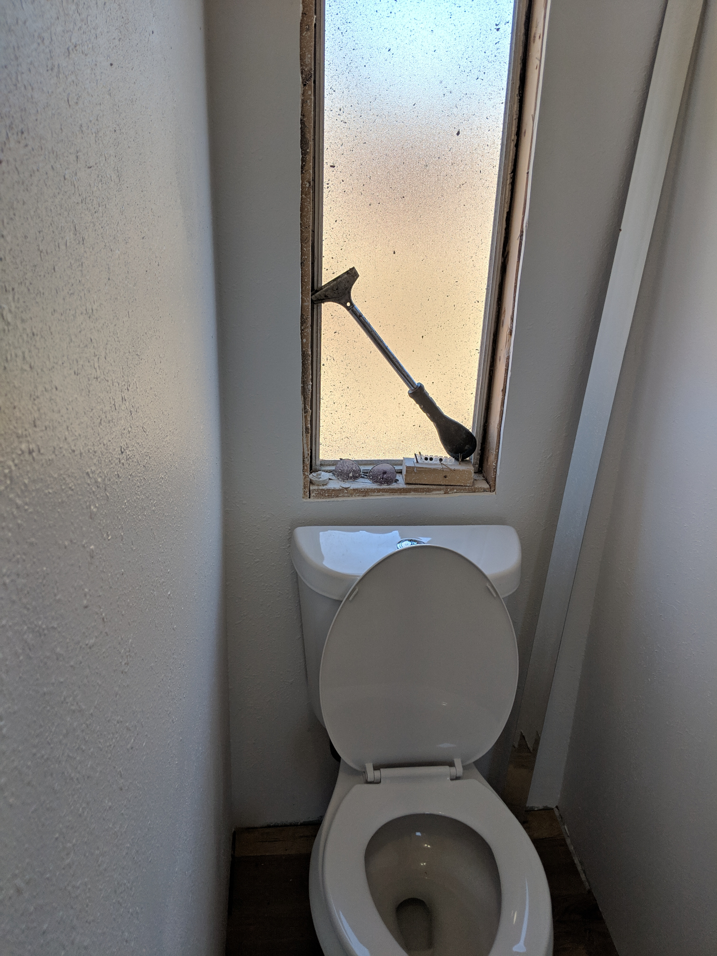 Before — an awkward window sat directly behind the toilet, leaving the water closet strangely exposed.