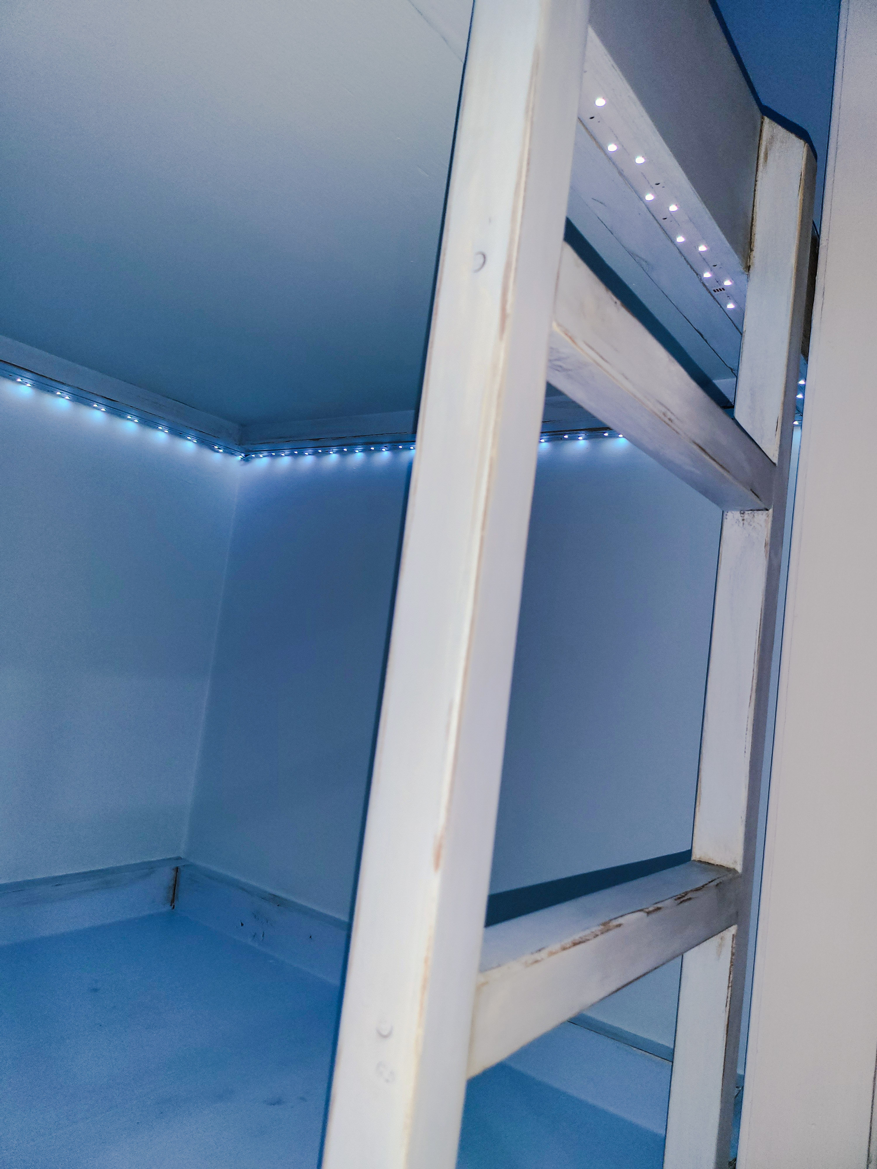 The coordinating weathered-white ladder and soft LED accent lighting.