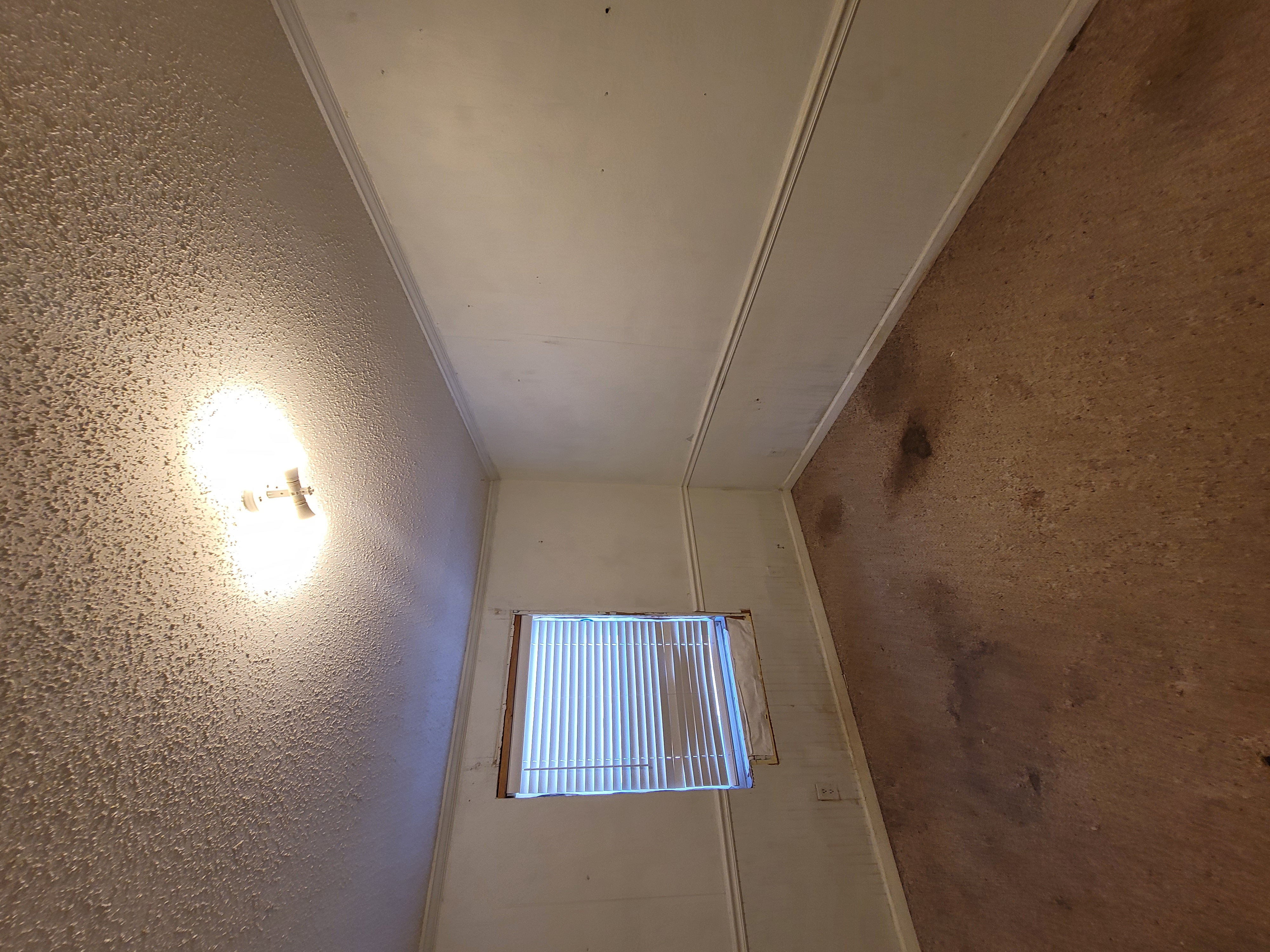 Before — an ordinary room with tired carpet, plain walls and an open closet.